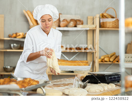 Young woman works in bakery as baker, kneads and prepare dough, works with flour. Young woman works in bakery as baker, kneads and prepare dough, works with flour. 122438922