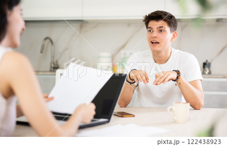 Young guy discussing deal with saleswoman in kitchen Young guy discussing deal with saleswoman in kitchen 122438923