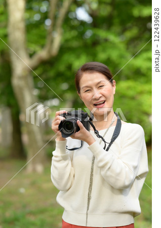 カメラを構えるシニア女性 122439628