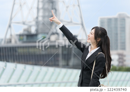 都会で指差しをするビジネスウーマン 都会で指差しをするビジネスウーマン 122439740