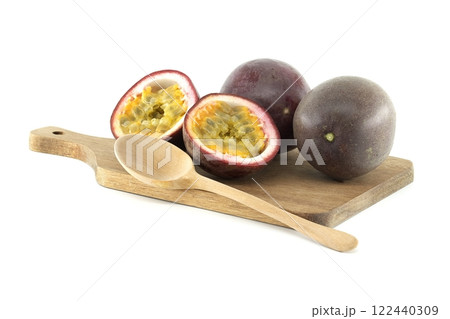Fresh passion fruits and wooden spoon lying on cutting board 122440309