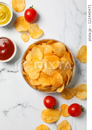 Potato chips in a bowl with sauce and tomatoes on a light background 122440471
