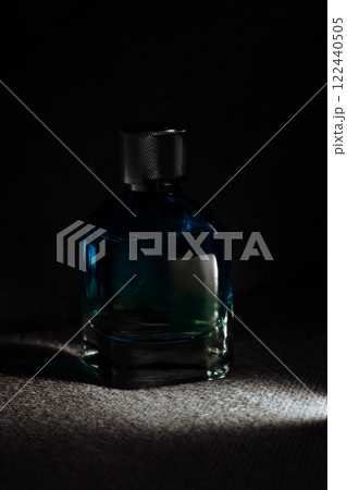 Bottle of perfume with fume on dark background Bottle of perfume with fume on dark background 122440505