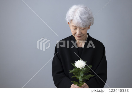 喪服を着て菊の花を持っているシニア女性 喪服を着て菊の花を持っているシニア女性 122440588