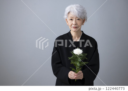 喪服を着て菊の花を持っているシニア女性 122440773