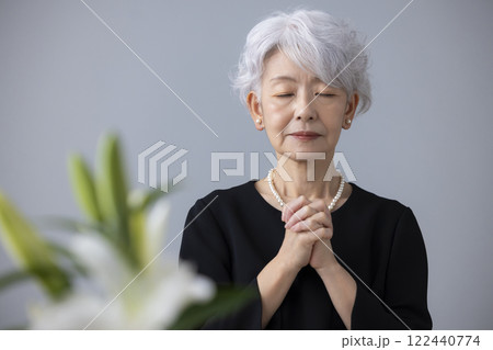 喪服を着て祈るシニア女性 122440774
