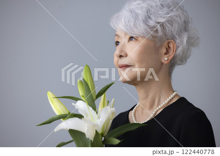 喪服を着て百合の花を持っているシニア女性 喪服を着て百合の花を持っているシニア女性 122440778