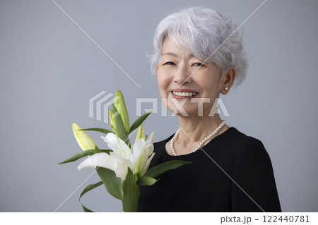 喪服を着て百合の花を持っているシニア女性 喪服を着て百合の花を持っているシニア女性 122440781