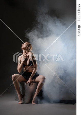 Artistic portrait of a woman in a smoky atmosphere during a studio session 122441055