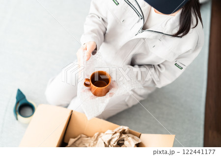 割れないように食器を丁寧に梱包する引越業社スタッフ 顔無し 割れないように食器を丁寧に梱包する引越業社スタッフ 顔無し 122441177