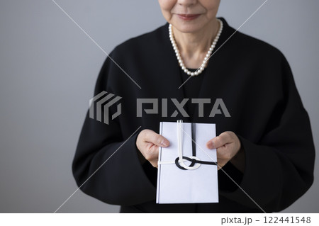 香典袋を差し出す女性の手元 香典袋を差し出す女性の手元 122441548