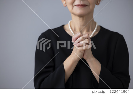喪服を着て祈るシニア女性の手元 喪服を着て祈るシニア女性の手元 122441904