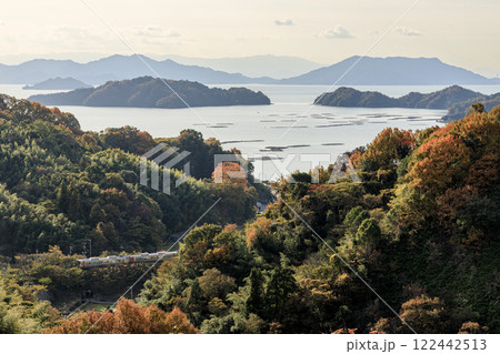 傾いた陽射しが瀬戸の島影と紅葉の名残を穏やかに写し出す 122442513