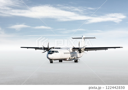 White passenger turboprop aircraft isolated on bright background with sky 122442830