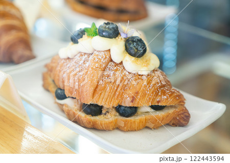 Blueberry Cream Croissant with Powdered Sugar on a White Plate 122443594