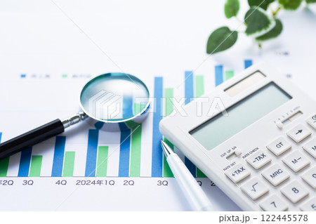 会社の業績グラフと電卓とルーペ 122445578