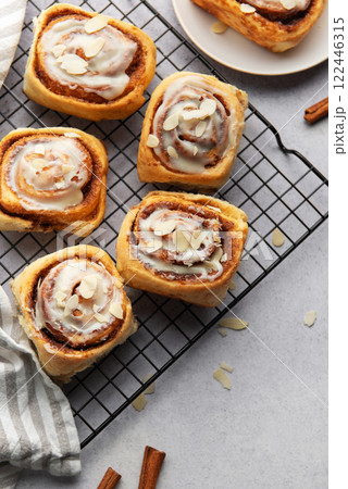 Freshly baked cinnamon rolls cooling on a wire rack 122446315