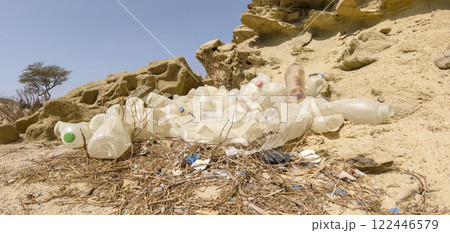 Dump of old plastic scorched by the sun, in the desert, on the background of stones and wood in the desert 122446579