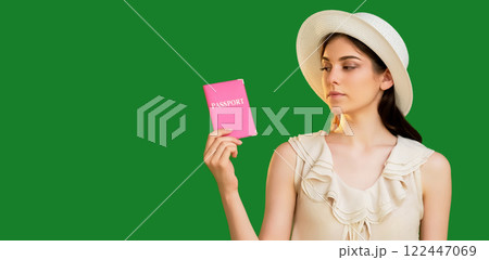 Upset tourist woman in summer hat holding pink passport international id document isolated on green copy space background. Upset tourist woman in summer hat holding pink passport international id document isolated on green copy space background. 122447069
