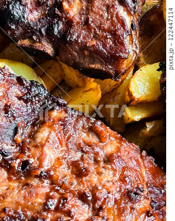 Grilled barbecue ribs on roasted potatoes 122447114