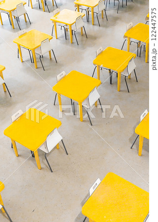 Top view of rows of yellow tables and white chairs Top view of rows of yellow tables and white chairs 122447575