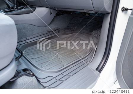 Dirty car floor mats of black rubber under passenger seat in the workshop for the detailing vehicle before dry cleaning. Auto service industry. Interior of sedan. 122448411