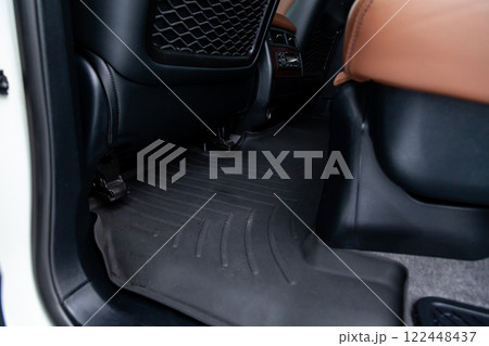 Clean car floor mats of black rubber under rear passenger seat in the workshop for the detailing vehicle dry cleaning. Auto service industry. Interior of sedan. 122448437