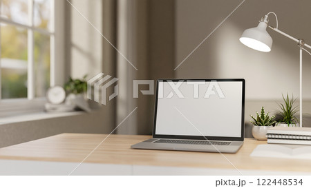 A close-up of a laptop on a minimalist wooden table in a white contemporary room. A close-up of a laptop on a minimalist wooden table in a white contemporary room. 122448534