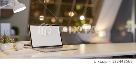 A white tabletop with a laptop and decorative items, set in a cozy contemporary room at night. A white tabletop with a laptop and decorative items, set in a cozy contemporary room at night. 122448569