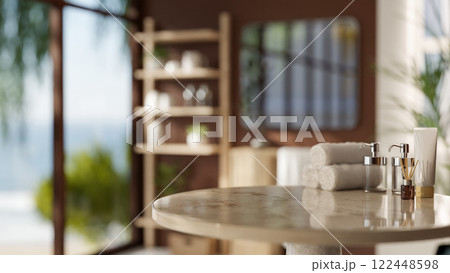A round marble table features towels and bath products, set in a modern, brown bathroom. A round marble table features towels and bath products, set in a modern, brown bathroom. 122448598