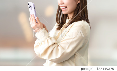 笑顔でスマートフォンを使う女性・ビジネスウーマン 笑顔でスマートフォンを使う女性・ビジネスウーマン 122449870