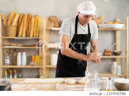 Elderly man baker making pieces of dough 122450786