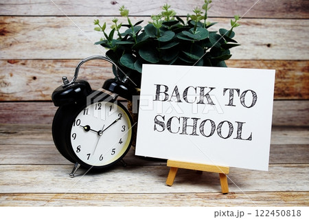Back to School texte on paper card with easel and alarm clock on wooden bacground, Education concept 122450818