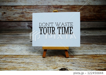 Don't waste your time Quote text on paper card with easel on wooden background 122450844