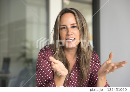 Businesswoman speaking during virtual meeting with corporate client 122451060