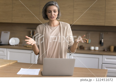 Aged lady freelancer speak to client online using notebook webcam Aged lady freelancer speak to client online using notebook webcam 122451072