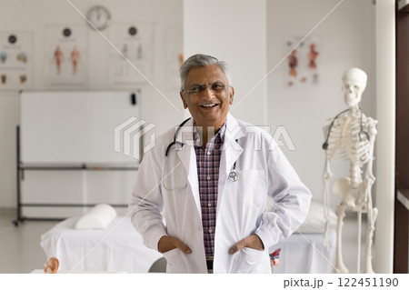 Portrait happy successful senior male doctor standing at modern cabinet 122451190
