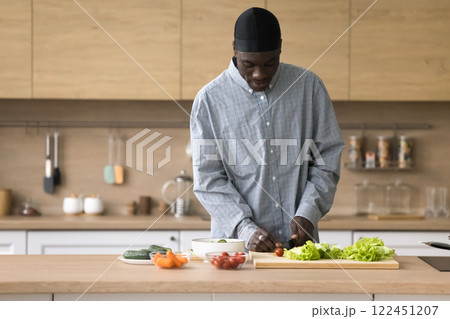 Busy mid aged African American man cooking in home kitchen 122451207