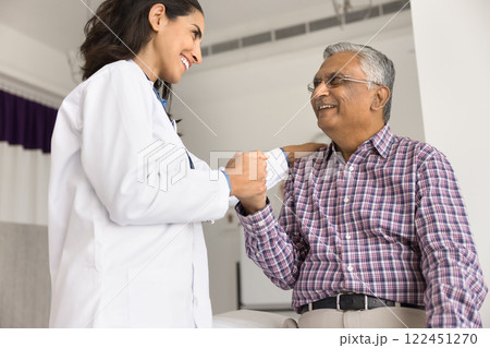 Female doctor hold hand on shoulder of older male patient 122451270
