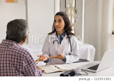 Confident young female doctor speak to elderly patient at hospital Confident young female doctor speak to elderly patient at hospital 122451361