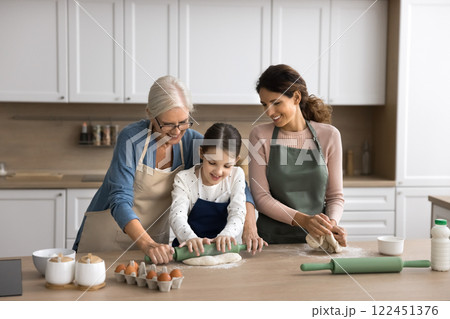 Older grandma young mum little girl cook pie at kitchen Older grandma young mum little girl cook pie at kitchen 122451376