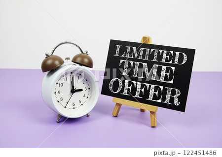 Limited Time Offer text written on paper card with alarm clock on purple background Limited Time Offer text written on paper card with alarm clock on purple background 122451486