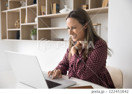 Happy woman working on computer in home office Happy woman working on computer in home office 122451642