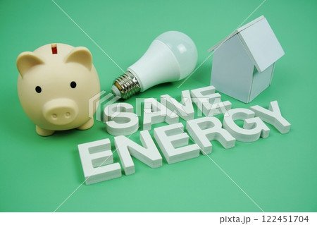 Save Energy alphabet letters with house model, piggy bank and LED light bulbs on green background, Saving and Eco friendly concept 122451704