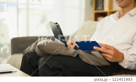 Adult man using digital tablet checking financial records and managing accounts at home 122451983