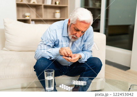 Middle aged senior man with medical pill and glass of water. Mature old senior grandfather taking medication cure pills vitamin. Age prescription medicine healthcare therapy concept Middle aged senior man with medical pill and glass of water. Mature old senior grandfather taking medication cure pills vitamin. Age prescription medicine healthcare therapy concept 122453042