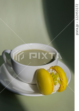 Green latte matcha with yellow macaron dessert on pastel background with creative deep shadows. Concept of holiday breakfast morning tea drink. Cozy minimalist superfood vibrant colors healthy eating 122453172