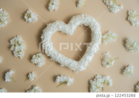 Symbol of love beautiful flower petals in heart shape in beige background. Creative concept of St Valentines day, weeding romantic date or anniversary. Copy space Symbol of love beautiful flower petals in heart shape in beige background. Creative concept of St Valentines day, weeding romantic date or anniversary. Copy space 122453268