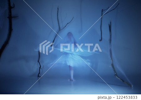 Spirit of dance, frozen in ghostly motion. Elegant ballerina in delicate movements stretch beyond time, fading into spectral light. 122453833