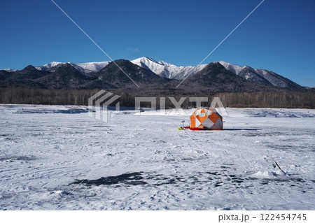 全面凍結した糠平湖のワカサギ釣りのテントから雪山を望む 全面凍結した糠平湖のワカサギ釣りのテントから雪山を望む 122454745
